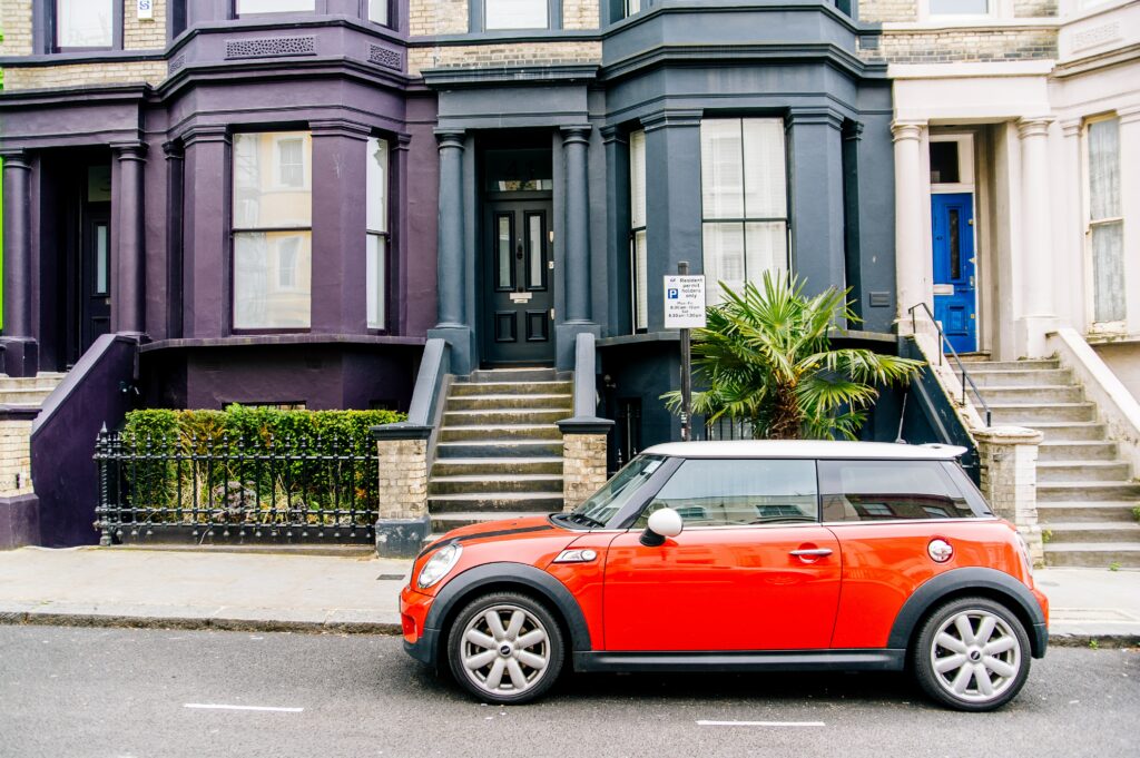 A red mini parked on the side of the road.