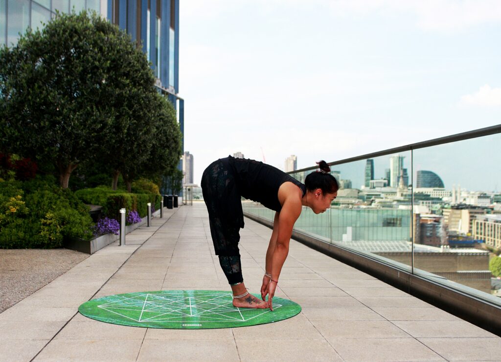 A woman is doing yoga on the sidewalk